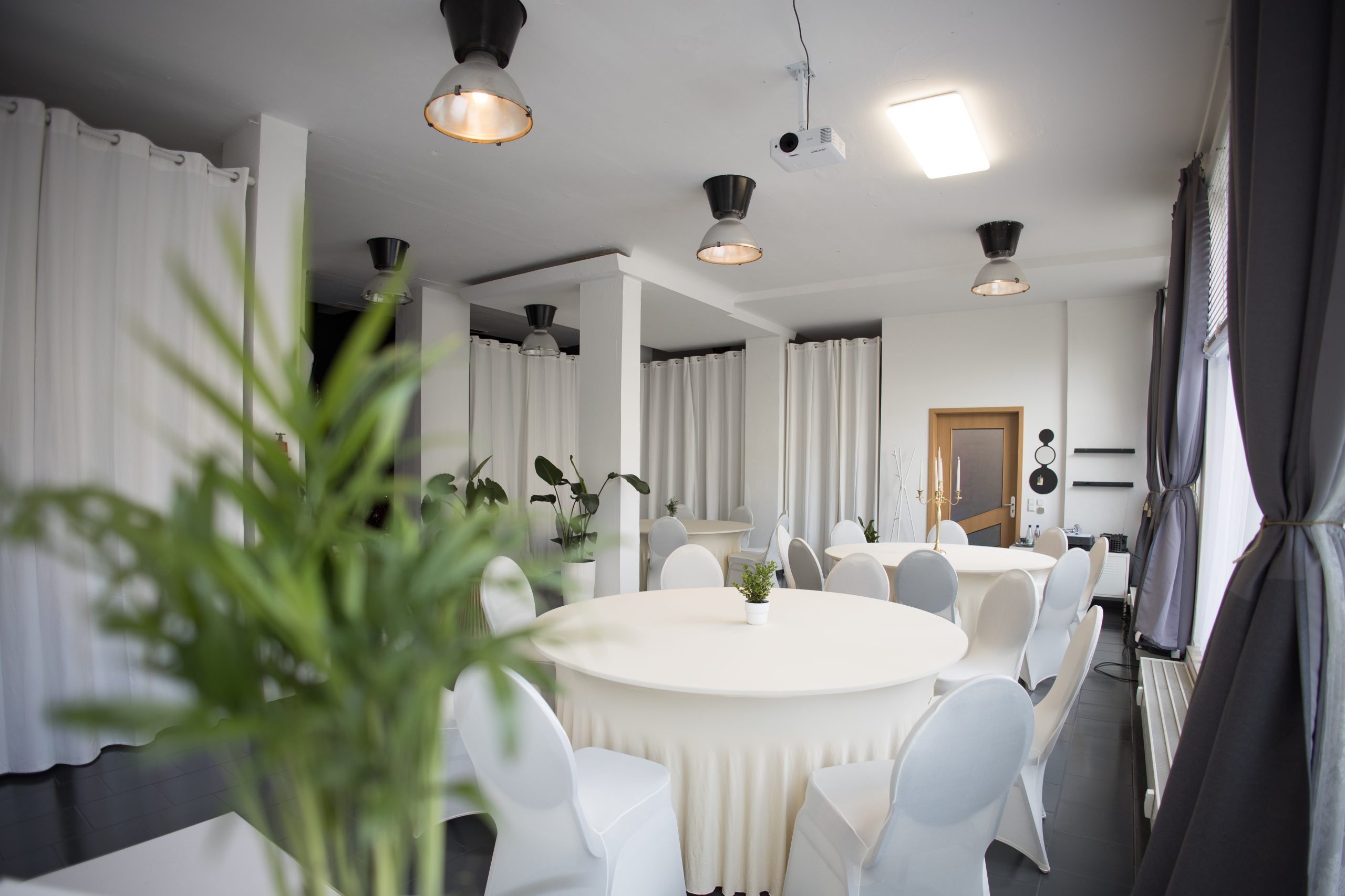 Diner-Setup im Studio 1 mit gedeckten Tischen und warmem Licht